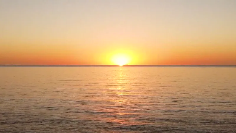 El sol poniéndose sobre el mar calmo